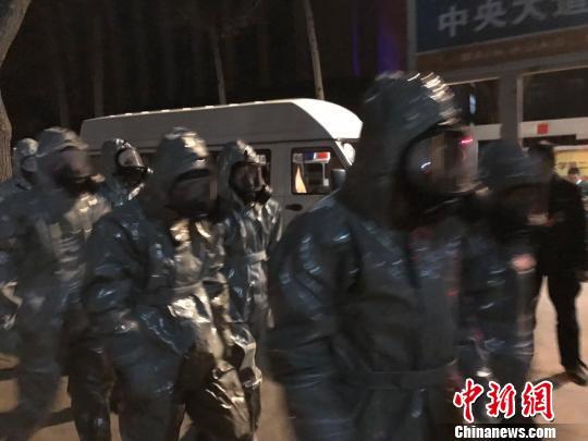 十几名身着防护服的人员头戴面具进入事发地。　胡健 摄
